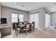Elegant dining room featuring a formal dining table, modern tile floors, and a convenient wet bar area at 8934 Windgate Ranch St, Las Vegas, NV 89166