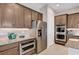 Modern kitchen features stainless steel appliances, granite countertops, and custom wood cabinetry at 8934 Windgate Ranch St, Las Vegas, NV 89166