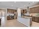 Open kitchen with stainless steel appliances, generous counter space, and modern brown cabinetry at 8934 Windgate Ranch St, Las Vegas, NV 89166