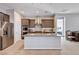 Gourmet kitchen with stainless steel appliances, a large island, and sleek cabinetry and door to pantry at 8934 Windgate Ranch St, Las Vegas, NV 89166