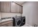 Spacious laundry room with updated washer and dryer and custom cabinetry at 8934 Windgate Ranch St, Las Vegas, NV 89166