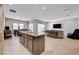 Open-concept living area featuring a kitchen island, formal dining area, and spacious living room with TV at 8934 Windgate Ranch St, Las Vegas, NV 89166