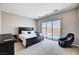 Spacious bedroom with backyard pool access through sliding glass doors with a decorative king bed at 8934 Windgate Ranch St, Las Vegas, NV 89166