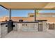 Fully equipped outdoor kitchen featuring modern appliances, stainless steel accents, and ample counter space at 8934 Windgate Ranch St, Las Vegas, NV 89166
