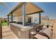 Covered outdoor kitchen with bar seating and high-end appliances, perfect for outdoor entertaining at 8934 Windgate Ranch St, Las Vegas, NV 89166