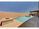 A backyard pool with a tanning ledge, integrated spa and a custom built-in outdoor kitchen, and lots of privacy at 8934 Windgate Ranch St, Las Vegas, NV 89166