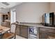 Close-up of a wet bar featuring granite countertops, a sink, a beverage cooler, and custom cabinets at 8934 Windgate Ranch St, Las Vegas, NV 89166
