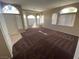 Open living area with plush carpet, high ceilings, bright windows, and arched entryways at 8959 Coral Shale St, Las Vegas, NV 89123