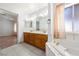 Bathroom featuring a double sink vanity, large soaking tub and an open concept design at 901 E Jaybird St, Pahrump, NV 89048