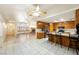 Open kitchen with tile countertops and a breakfast bar seamlessly connecting to the living room at 901 E Jaybird St, Pahrump, NV 89048