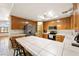Well-lit kitchen boasting tile countertops and wooden cabinetry and breakfast bar at 901 E Jaybird St, Pahrump, NV 89048