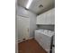 Functional laundry room with washer, dryer, storage cabinets, and easy outdoor access at 9530 Windsor Forest Ct, Las Vegas, NV 89123