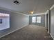 Spacious living room featuring plush carpeting, neutral walls, and ample natural light from the many windows at 9530 Windsor Forest Ct, Las Vegas, NV 89123