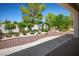 Serene backyard with manicured landscaping, gravel beds, and a covered patio, perfect for relaxation at 9704 Brawley Dr, Las Vegas, NV 89134