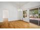 Open dining room with hardwood floors, neutral paint, decorative chandelier, and sliding glass door to the yard at 9704 Brawley Dr, Las Vegas, NV 89134
