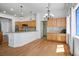 Spacious kitchen with hardwood floors, modern lighting, and breakfast bar, open to dining area at 9704 Brawley Dr, Las Vegas, NV 89134