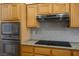 Close-up of the kitchen featuring modern appliances, granite countertops, and tile backsplash at 9704 Brawley Dr, Las Vegas, NV 89134