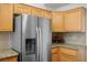 Modern stainless steel refrigerator complemented by wooden cabinets and granite countertops at 9704 Brawley Dr, Las Vegas, NV 89134