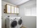 Bright laundry room with storage cabinets, modern washer and dryer, and a window for natural light at 9704 Brawley Dr, Las Vegas, NV 89134