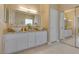 Bathroom with double sinks, decorative mirror, and tile flooring at 10243 Songsparrow Ct, Las Vegas, NV 89135