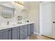 Modern bathroom featuring double vanity with marble countertop, round mirrors, and elegant gray cabinets at 10381 Borah Park Cir, Las Vegas, NV 89178