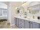 Stylish bathroom with double vanity, marble countertop, round mirrors, and entrance to the main bedroom at 10381 Borah Park Cir, Las Vegas, NV 89178