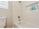 White tiled tub/shower featuring shampoo niche, modern fixtures, and an adjustable shower head at 10381 Borah Park Cir, Las Vegas, NV 89178