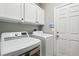 Bright laundry room with modern appliances and white cabinetry for storage at 10381 Borah Park Cir, Las Vegas, NV 89178