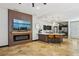 Open-concept living space with a modern fireplace, tile flooring, kitchen island with seating, and black cabinetry at 10381 Borah Park Cir, Las Vegas, NV 89178