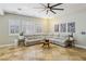 Spacious living room featuring neutral tones, large windows with shutters, and a comfortable sectional sofa at 10381 Borah Park Cir, Las Vegas, NV 89178