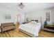 Bright main bedroom featuring a tufted headboard, wood floors, and a sitting area at 10381 Borah Park Cir, Las Vegas, NV 89178