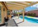 Backyard oasis with a refreshing pool, lush greenery, and comfortable seating for relaxation and entertaining at 10381 Borah Park Cir, Las Vegas, NV 89178
