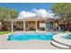 Beautiful backyard with a freeform pool, spa, covered patio, and manicured lawn at 10381 Borah Park Cir, Las Vegas, NV 89178