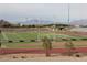 Well maintained, green football field with goal posts, track and bleachers under a cloudy sky at 11016 Meadow Leaf Ave, Las Vegas, NV 89144