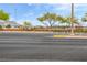 Street view of community featuring mature trees, privacy fence, and mountain views at 11016 Meadow Leaf Ave, Las Vegas, NV 89144