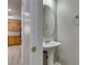 Updated powder room featuring pedestal sink, modern faucet, and decorative mirror at 11147 Verismo St, Las Vegas, NV 89141