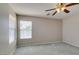 Carpeted bedroom with ceiling fan, light walls, and plenty of natural light from two windows at 11147 Verismo St, Las Vegas, NV 89141