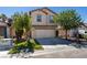 Two-story home featuring a two-car garage, front lawn, and mature trees at 11147 Verismo St, Las Vegas, NV 89141