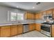 Sunlit kitchen showcases stainless steel appliances, wood cabinets, and light-colored countertops at 11147 Verismo St, Las Vegas, NV 89141