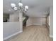Spacious living room with wood-look floors open to kitchen and staircase at 11147 Verismo St, Las Vegas, NV 89141