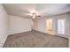 Spacious bedroom with ceiling fan, neutral carpet, and adjacent bathroom access for convenient living at 1197 Mission View Ct, Henderson, NV 89002