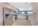 Bright kitchen featuring stainless steel appliances, granite counters, white cabinets, and wood tile flooring at 1466 Fieldbrook St, Henderson, NV 89052