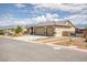 A single-story home with a three car garage and desert landscaping on a sunny day at 171 Weeping Willow Ct, Pahrump, NV 89048