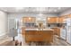 Open kitchen featuring granite countertops, stainless steel appliances, wood-look tile floors, and a center island at 171 Weeping Willow Ct, Pahrump, NV 89048