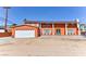 An exterior view of an orange two-story home with a garage, mature landscaping, and ample parking at 1818 Waldman Ave, Las Vegas, NV 89102