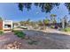 Large outdoor area with vegetation, debris, fencing, a tennis court, and various vehicles in the background at 1818 Waldman Ave, Las Vegas, NV 89102