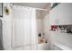 Bathroom featuring a shower-tub combo, white tile, and a variety of toiletries on the shelves at 1843 Mimosa Ct, Henderson, NV 89014