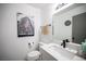 Bright bathroom with a sink, mirror, and toilet, decorated with a rustic barn art piece at 1843 Mimosa Ct, Henderson, NV 89014