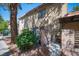 View of the townhome exterior showcasing the gated private entry, mature trees, and desert landscaping at 1843 Mimosa Ct, Henderson, NV 89014