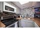Modern kitchen features gray cabinets, stainless steel appliances, and a stylish tile backsplash at 1843 Mimosa Ct, Henderson, NV 89014